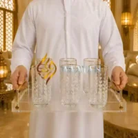 Elegant set of six glass tumblers with gold accents and leafy design, displayed on a clear acrylic tray.