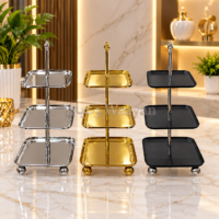 3-piece two-tier serving stand set in polished silver, glossy gold, and matte black metal with center posts and ball feet