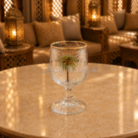 Stemmed clear glass goblet with gold rim and palm tree design