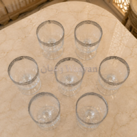 6pgs1.9 (4) Top-down view of a set of 6 clear glass drinking glasses with a silver patterned rim and short pedestal base