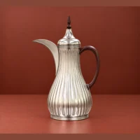 1L vacuum flask with a fluted silver-tone design 1L vacuum flask with fluted silver-tone body, curved spout and dark handle styled on a serving tray