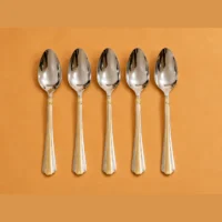 28 piece cutlery set with two-tone handles Five spoons with reflective surfaces and decorated two-tone handles