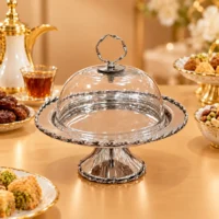 Silver polished metal cake stand with clear glass domed lid, braided rim, and ring handle