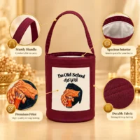 4F4E9814-3D8A-49D2-BD2B-9959BBD18760 Burgundy fabric cylindrical tote bag with canvas front print, single top handle, and white lined interior