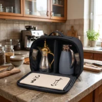 Gemini_Generated_Image_i4srzwi4srzwi4sr Open interior of black fabric case with silver dallah coffee pot, gold domed lid, and matte blue thermos with chrome handle