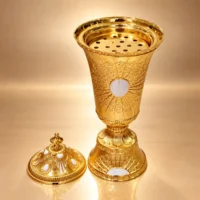 incense burner in polished gold embossed metal with white inlays, domed lid and perforated insert